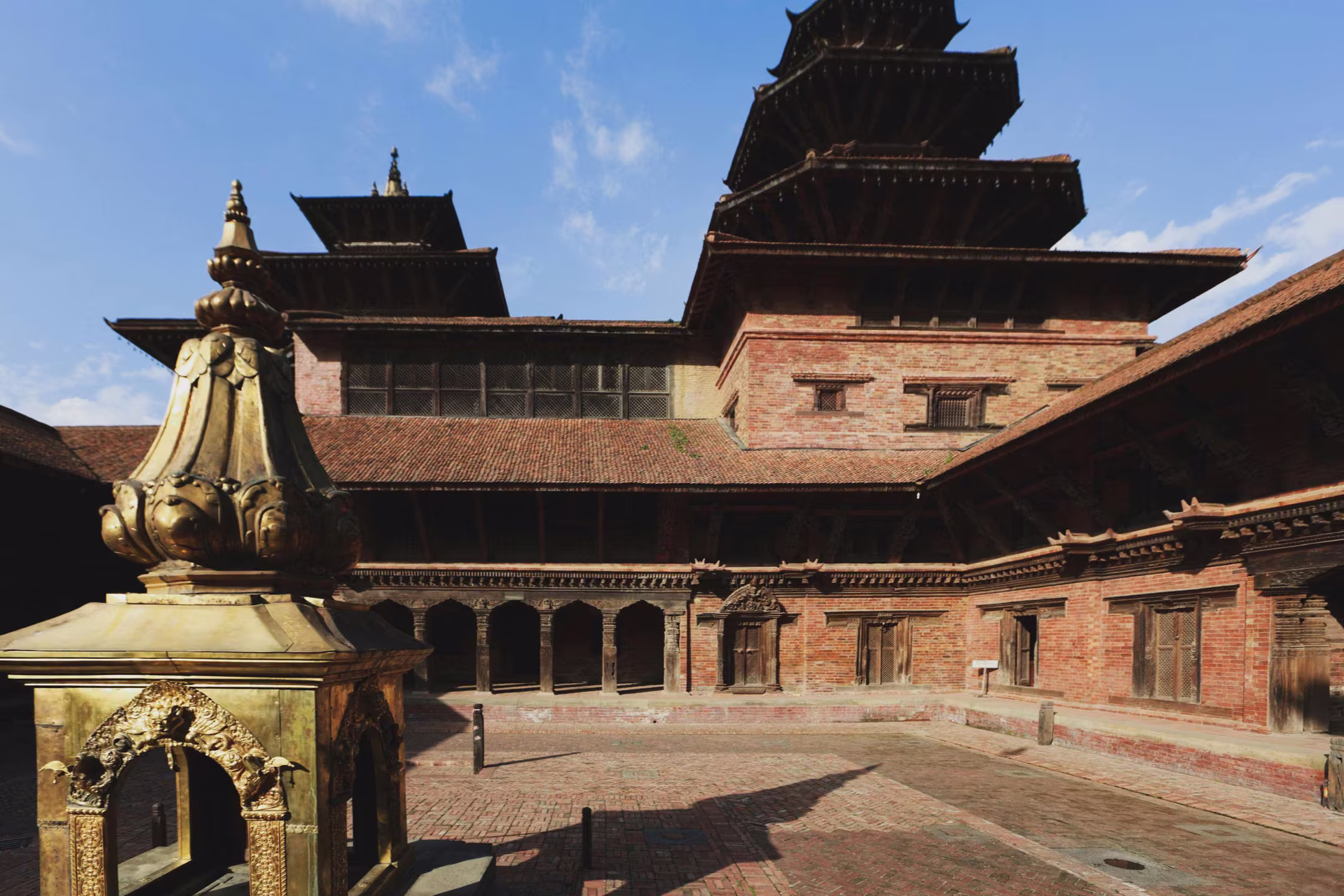 A golden sculpture in a temple courtyard