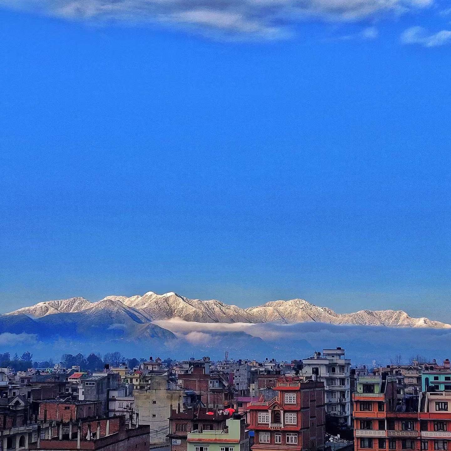 Kathmandu city skyline with the snow-capped Himalayan mountain range rising behind it