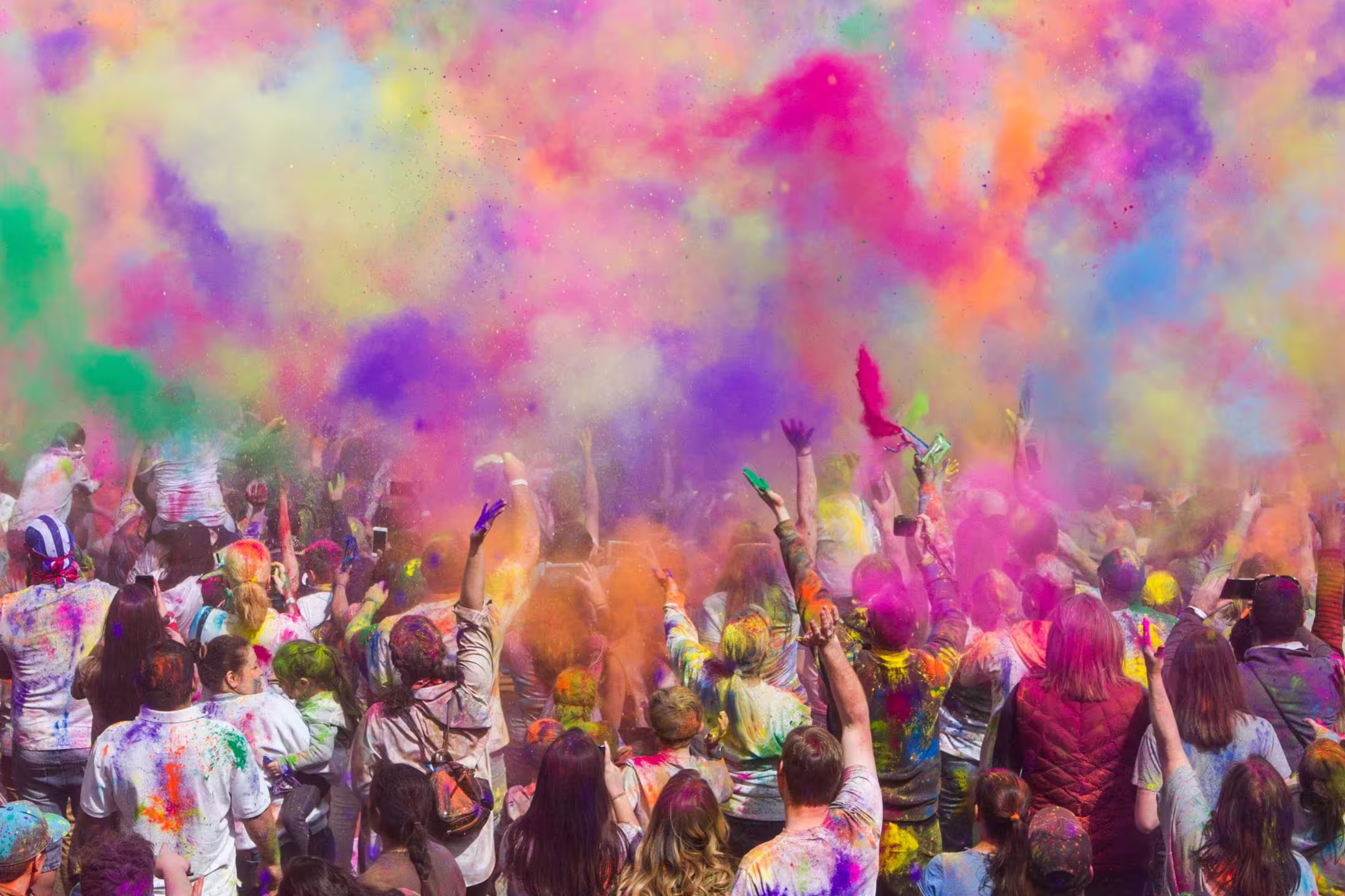 People throwing vibrant colours in the air during Holi festival in Nepal