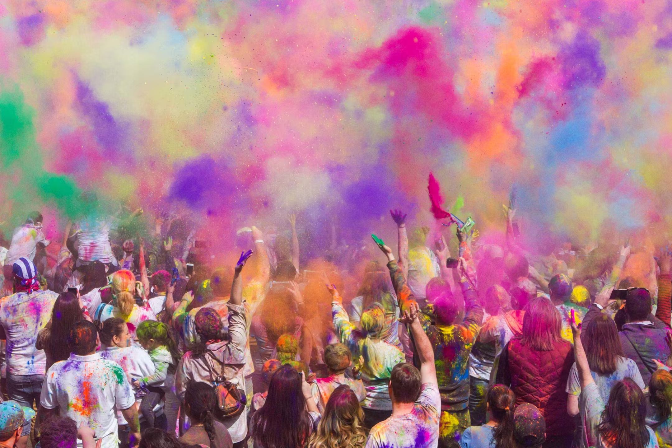 People throwing vibrant colours in the air during Holi festival in Nepal
