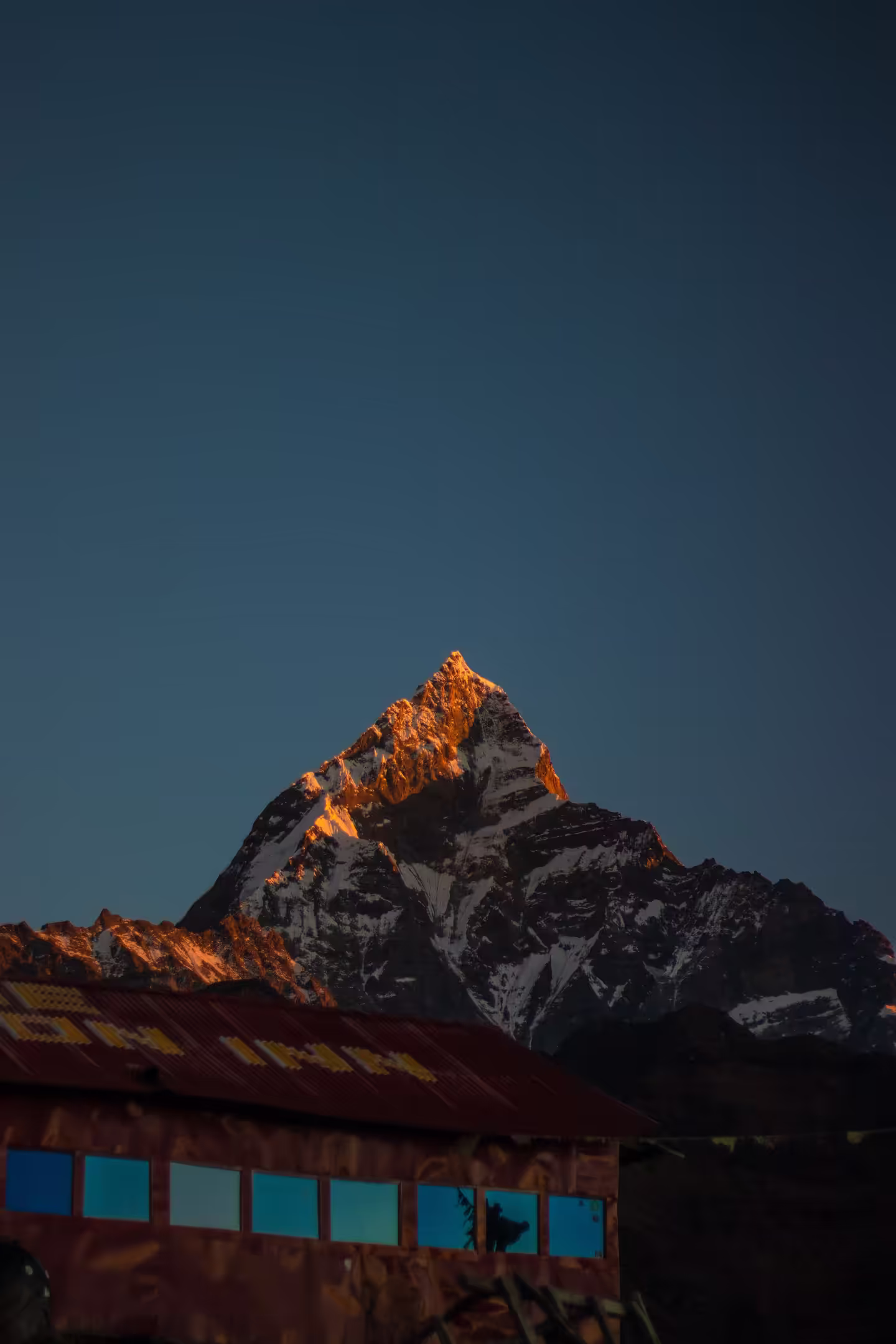 A teahouse on the trekking trail with a dramatic snow-covered mountain backdrop