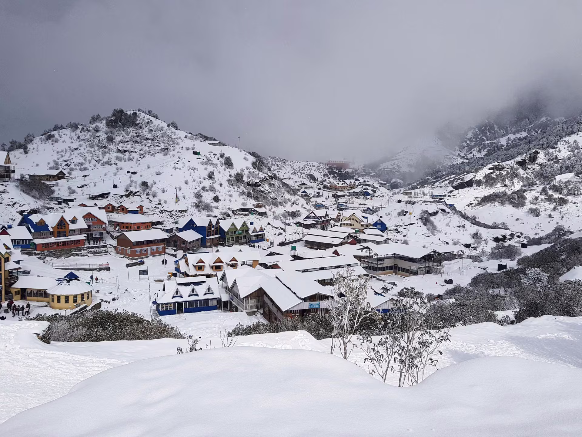 Snow-covered village with dramatic snowy mountain peaks in the background in winter Nepal